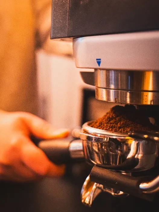Café recién molido cayendo en el portafiltro