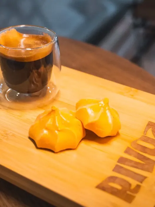 Espresso y merengues sobre la bandeja de madera con el logo de RIVOZ