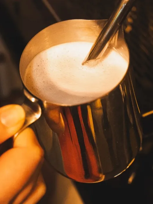 Leche vaporizándose en una jarra de acero